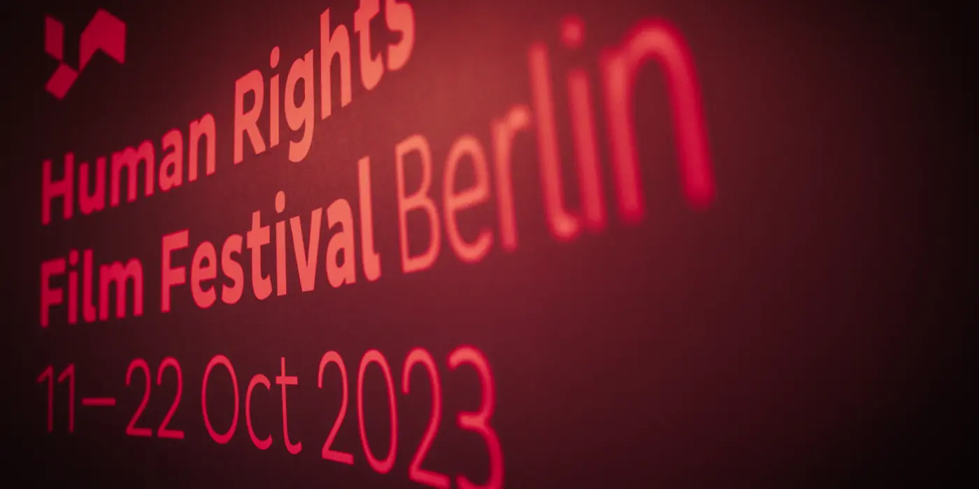 Werbebanner Human Rights Film Festival. Illuminated wall text “Human Rights Film Festival Berlin 11–22 Oct 2023”.
