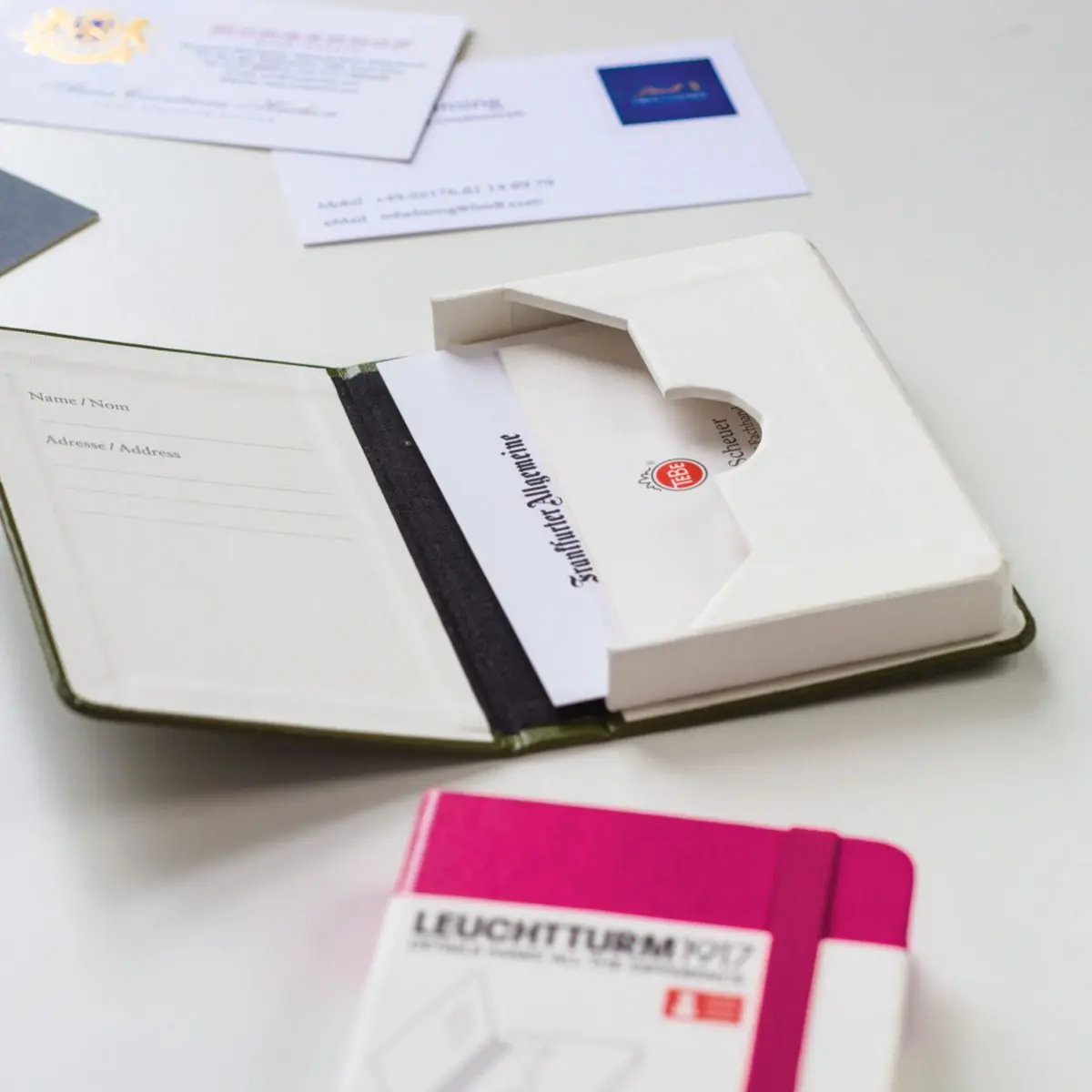leuchtturm1917-Etuis Opened cover with integrated pocket and cards, pink notebook in the foreground.