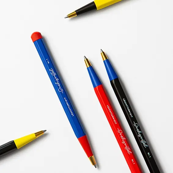 Drehgriffel No. 1 - Bauhaus Edition in primary colours. Ballpoint pens in yellow-black, blue-red and black-blue, with gold-coloured tip.