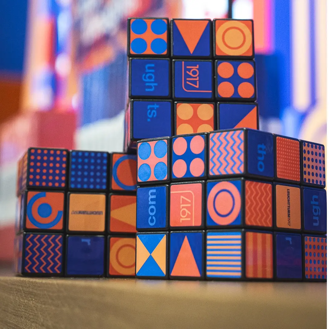 LEUCHTTURM1917 Promo-Rubik’s Cubes auf der Ambiente Messe 2024. Rubik’s-style cubes with colourful LEUCHTTURM1917 graphics, patterns and numbers, decorative display.