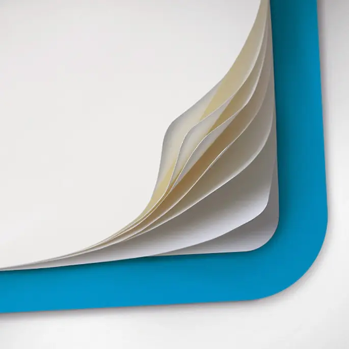 Leuchtturm1917 detail image 120 gsm paper Edition 120G. Corner of a notebook with fanned blank pages and blue cover.