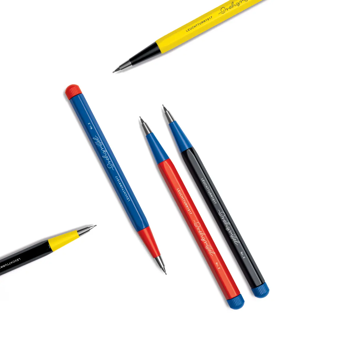 Mehrere Drehgriffel Nr. 2 der Bauhaus Edition in Gelb, Blau, Rot und Schwarz mit silberner Spitze auf weißem Hintergrund.