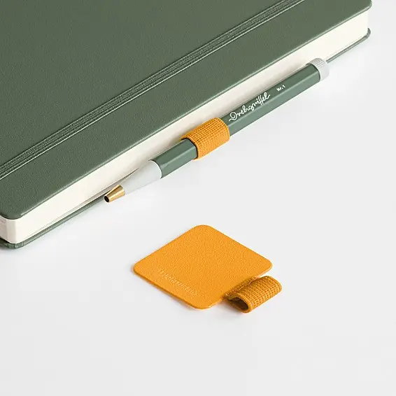 leuchtturm1917-pen-loop Green notebook with attached green Drehgriffel Nr. 1 and separate yellow pen holder.