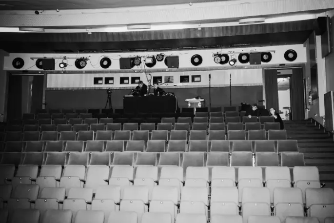 Kinosaal des Human Rights Film Festivals. Black-and-white image of a cinema hall with empty seats and technical area.