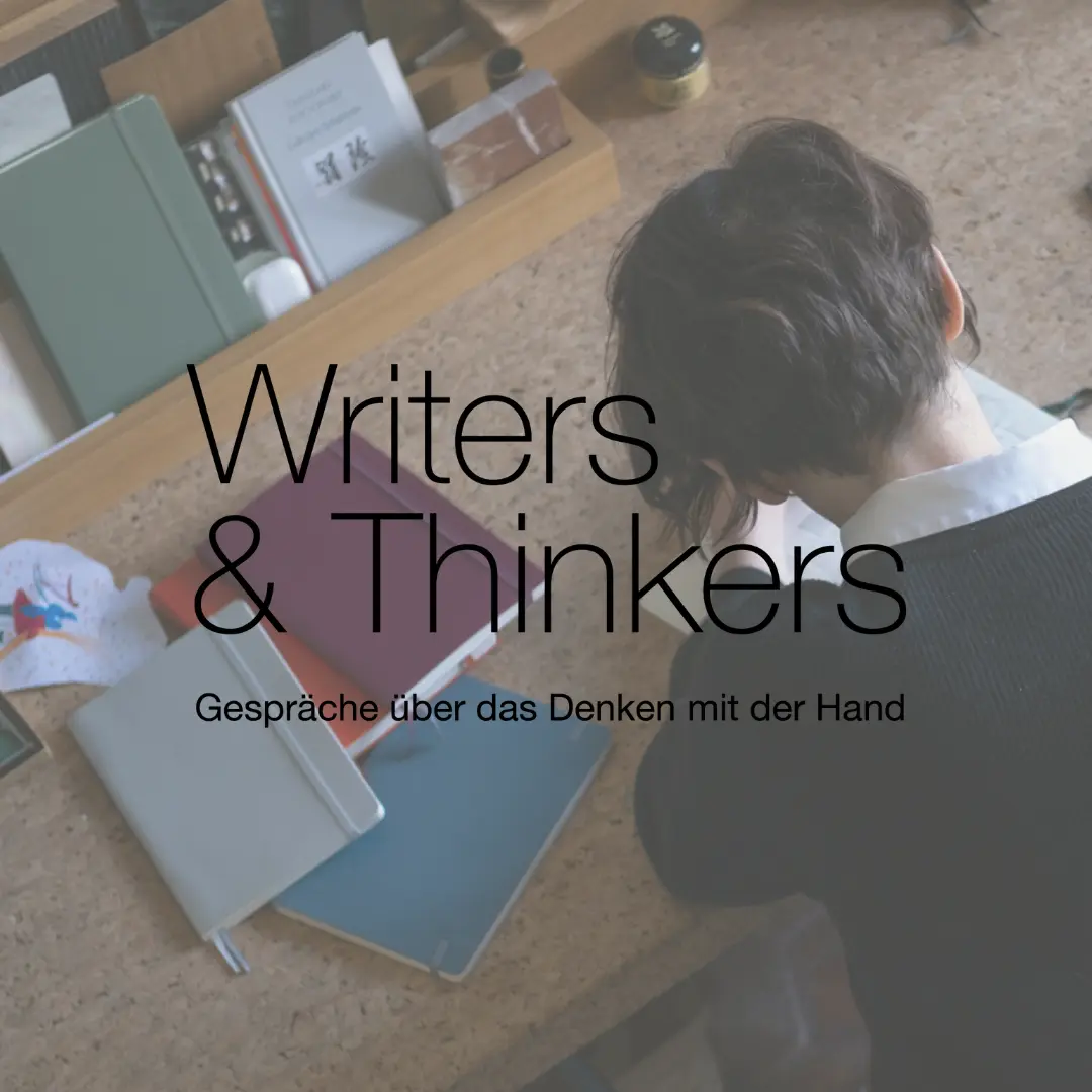 Person sitzt an einem Schreibtisch und schreibt in ein Notizbuch; davor liegen mehrere farbige Notizbücher. Über dem Bild steht der Text „Writers & Thinkers – Gespräche über das Denken mit der Hand“.