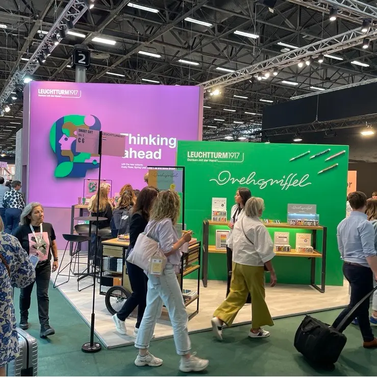 LEUCHTTURM1917 Messestand mit Drehgriffel-Präsentation LEUCHTTURM1917 trade fair booth with wall graphics “Drehgriffel” and “thinking ahead”.