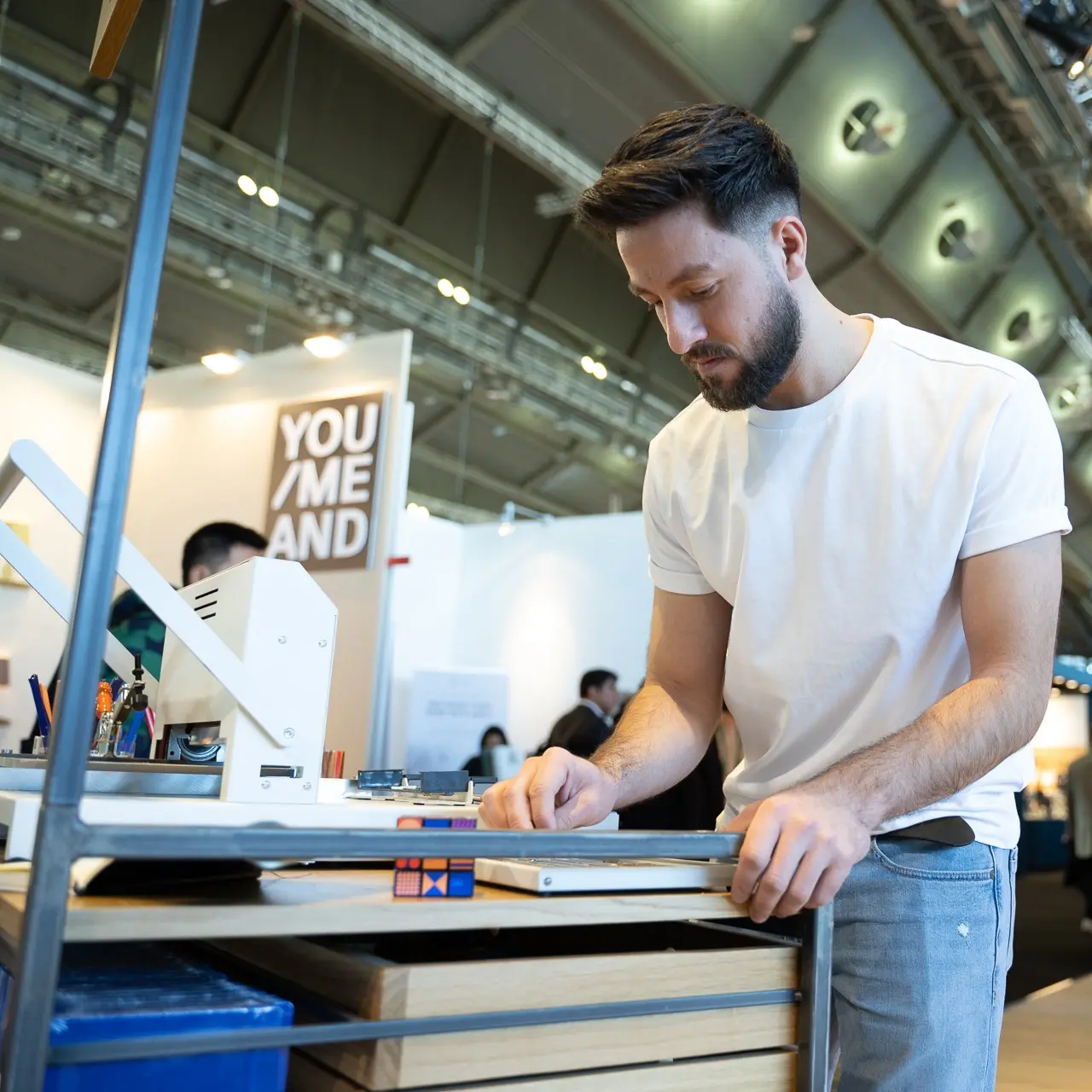 Drehgriffel-Gravur am Leuchtturm1917 Stand – Ambiente Messe 2024 Person embossing a book, inserting letters into the embossing machine at the LEUCHTTURM1917 booth.