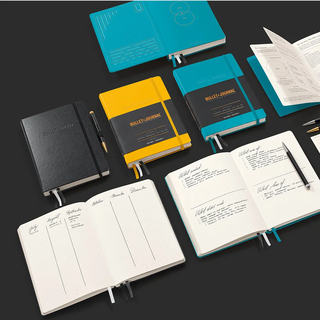 Bullet Journal Edition 2 – Farbenvielfalt und Innenansichten Bullet Journal notebooks in turquoise, yellow and black with Drehgriffel and open dotted pages.