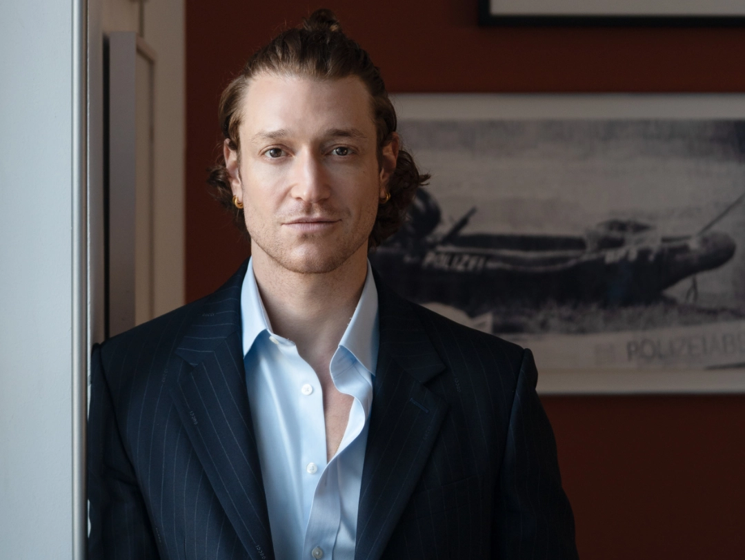 Daniel Donskoy steht neben einem Schrank und blickt in die Kamera