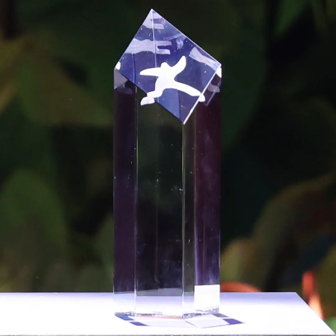 Gläserne First Steps Trophäe. Glass trophy with white human silhouette on a base.