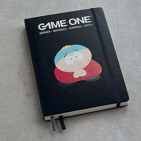 Black notebook with cartoon figure, text “GAME ONE”, elastic band and bookmark.