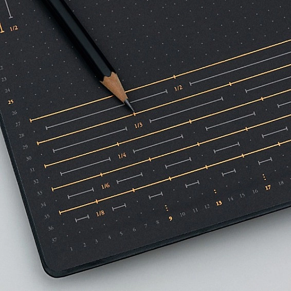 Black dotted notebook page with ruler and grid markings in gray and gold, black pencil.