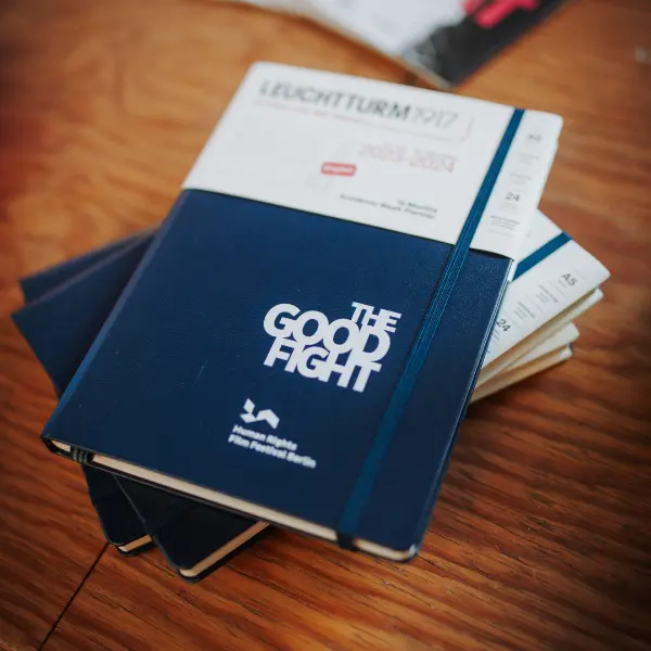 The good fight: Human Rights Film Festival Leuchtturm1917 Notizbuch. Dark blue LEUCHTTURM1917 notebook with elastic band, print “THE GOOD FIGHT”.