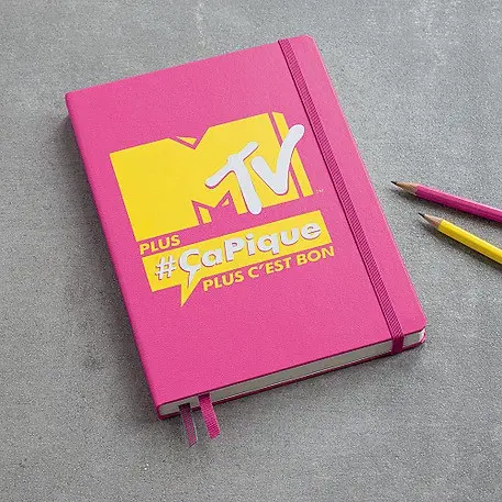 LEUCHTTURM1917 individuell gestaltbare Notizbücher. Pink notebook with text “MTV”, “#caPique” and “PLUS C’EST BON”, elastic band and bookmark.