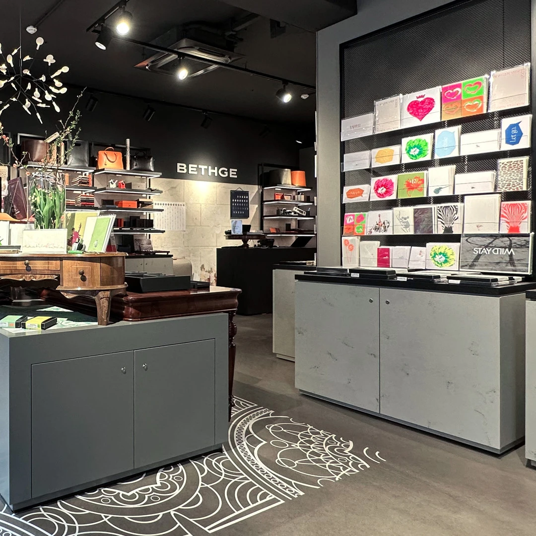 Bethge Store Hamburg mit Luminous Produkten. Retail space with shelves and product walls, leather goods in the background, sign “BETHGE”.