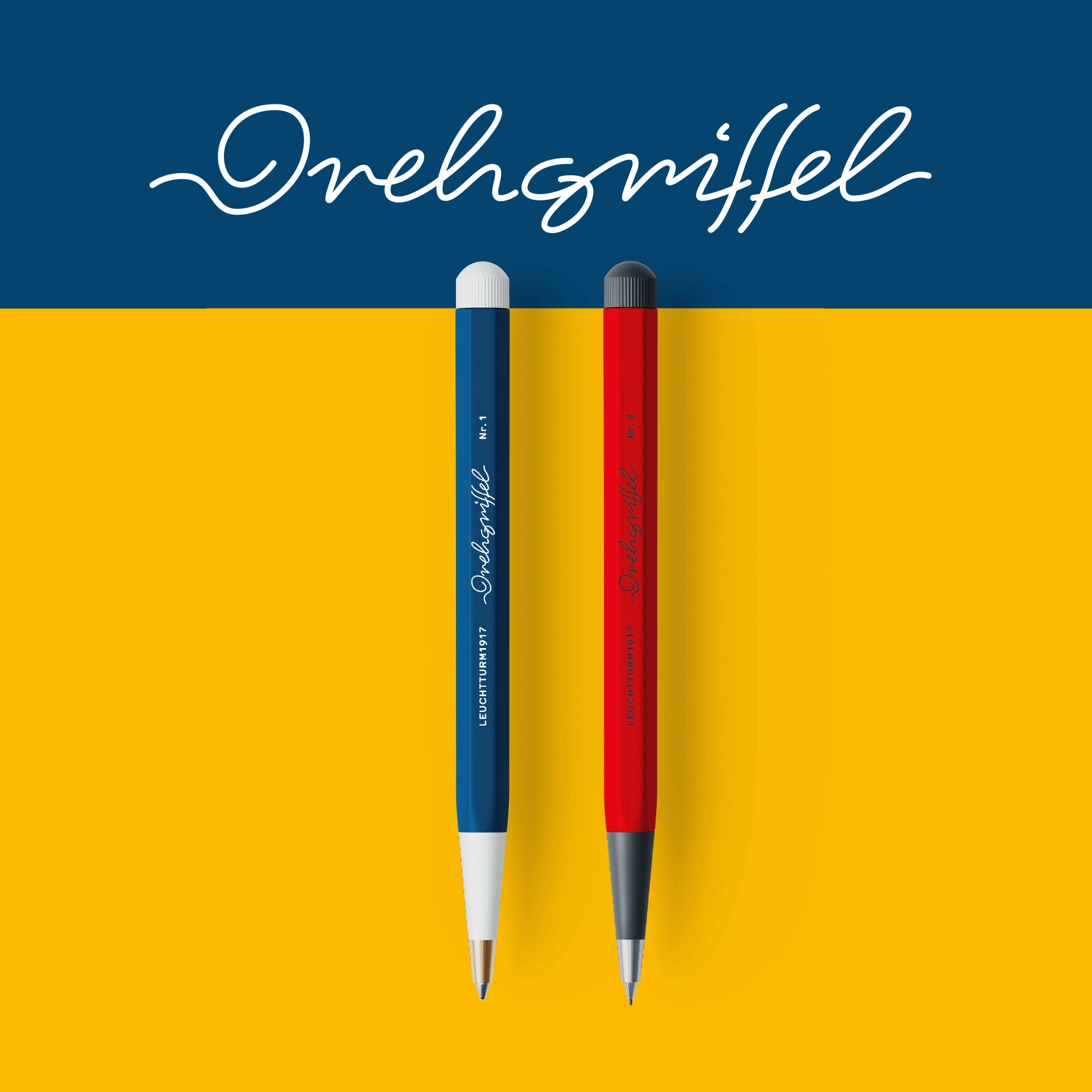 Drehgriffel in den neuen Farben 2026. Two Dreh pencils in blue and red on blue and yellow background. “Drehgriffel”.
