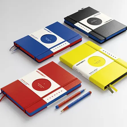 Bauhaus Edition - notebooks in four colours with Drehgriffel No. 1. Notebooks in blue, red, yellow and black with coloured page edges, two blue-red ballpoint pens in front.