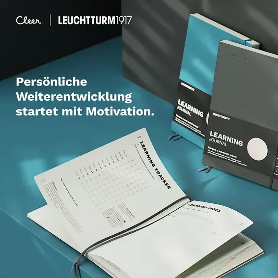 Leuchtturm1917 Learning Journal. Learning journals on table, one open. Text: “Persönliche Weiterentwicklung startet mit Motivation.”.