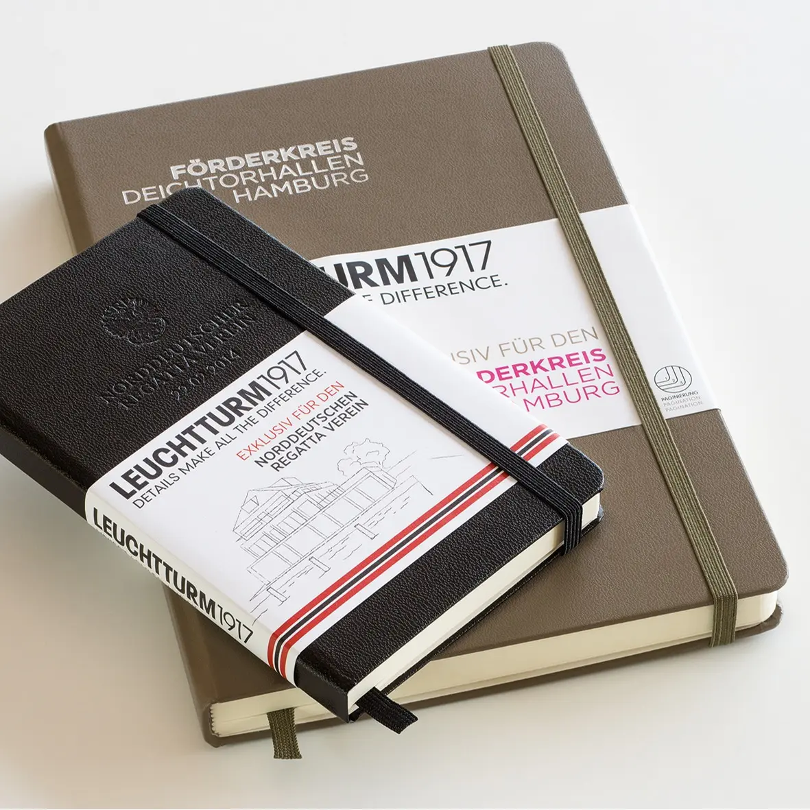 Two notebooks in black and brown with bands and elastic straps.