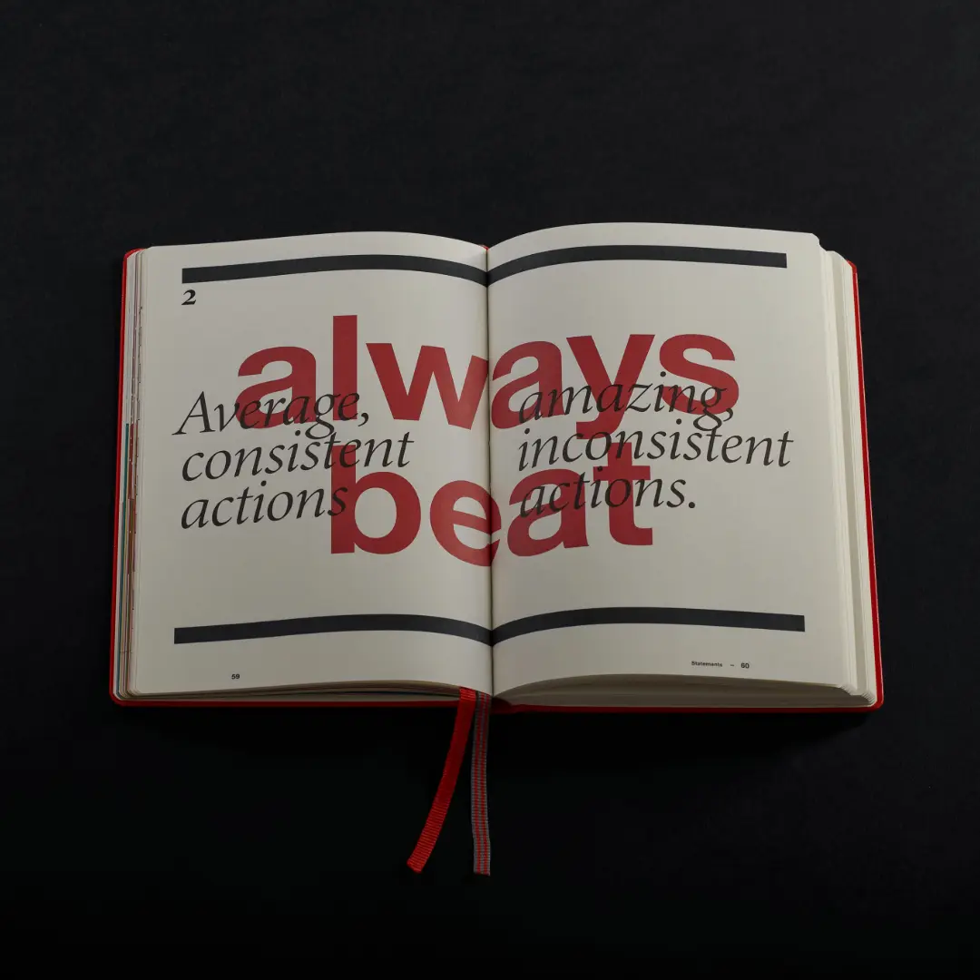 Finish Journal Beispielseite. Aufgeschlagenes Notizbuch mit Lesezeichen und rotem Text Always beat vor kursivem Zitat.